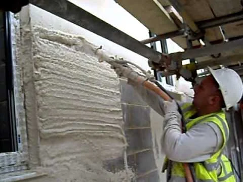 Judge Plastering contractor applying render wearing safety equipment