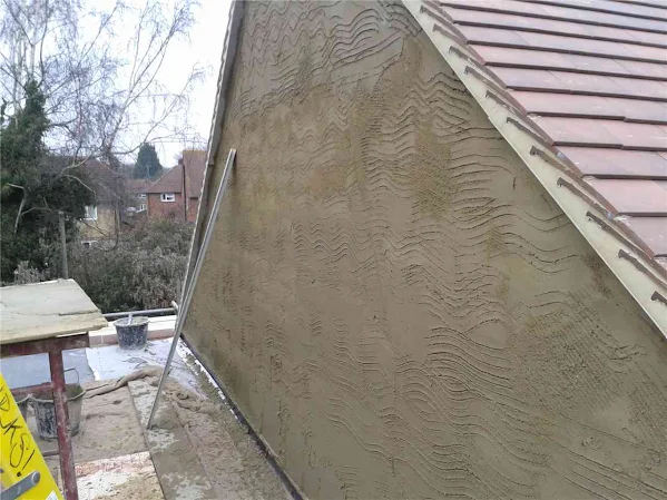 Scratch coat applied to gable end before rendering top coat